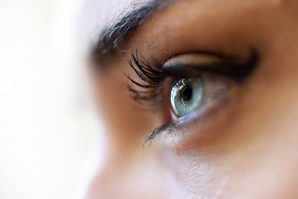 Close-up of young woman's blue eyes with long eyelashes. Make-eye